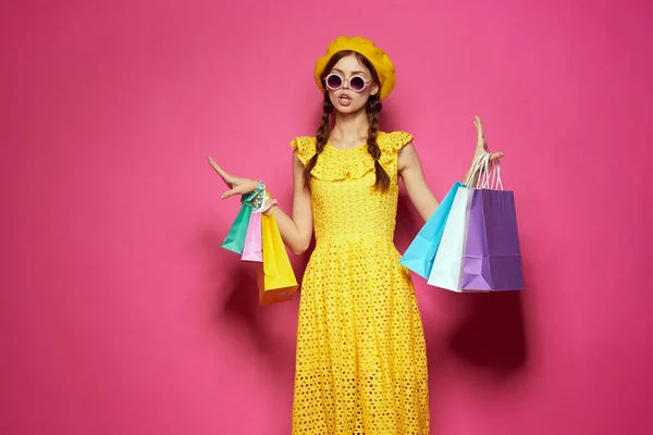 Donna sorridente in un cappello giallo Shopaholic moda stile studio modello — Foto Stock