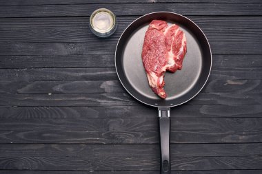 Kızartma tavasında biftek. Mutfak ahşap masa.