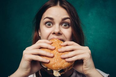 Hamburger yiyen bir kadın.