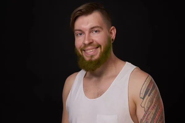 Homem barbudo elegante em uma camiseta branca com tatuagens em seus braços moda — Fotografia de Stock