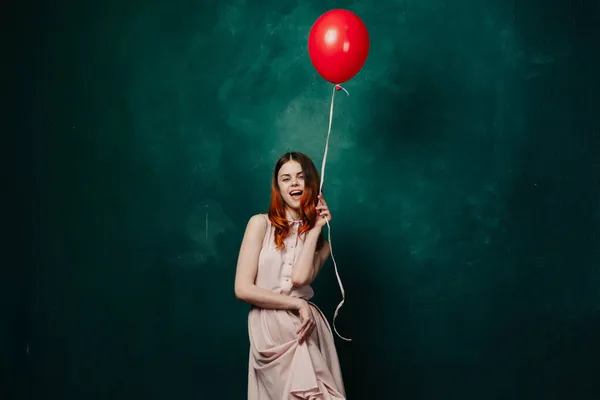 Hübsche Frau im Kleid roten Ballon Geburtstag grünen Hintergrund — Stockfoto