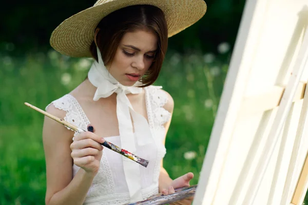 Kobieta artysta rysuje obraz na sztaludze na zewnątrz — Zdjęcie stockowe