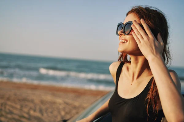 Frau am Strand ist mit Auto mit Sonnenbrille unterwegs — Stockfoto