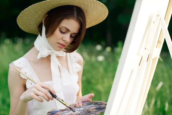 Žena malíř kreslí obrázek na stojanu venku — Stock fotografie