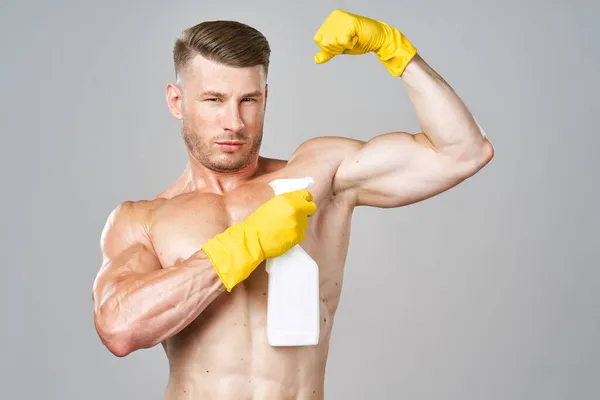 Man med pumpade muskler rengöringsmedel poserar rengöring — Stockfoto