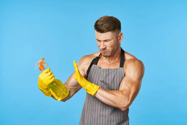 Un hombre con un cuerpo bombeado en la limpieza de detergentes delantales — Foto de Stock