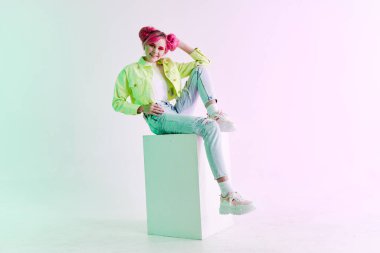 Pembe saçlı, yaratıcı stüdyo modeli olan şık bir kadın.
