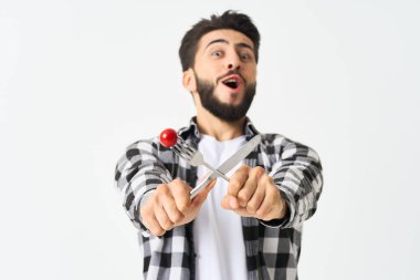 Mutfak aletleriyle sakallı adam. Kiraz domatesli atıştırmalık.