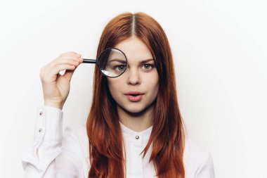 Yüzünde büyüteçle yüzünü buruşturan güzel bir kadın.