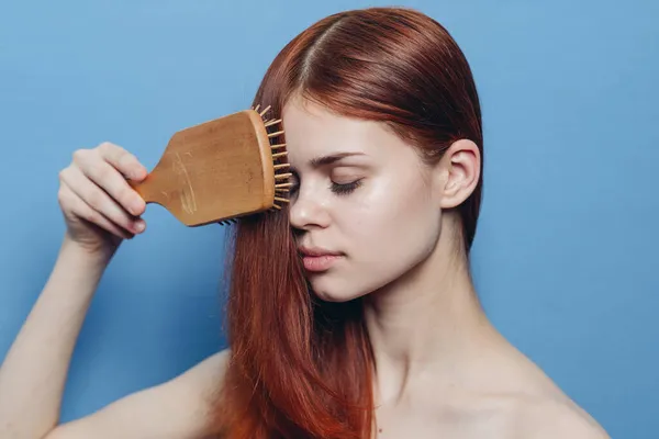 Красивая женщина расчесывает волосы голыми плечами уход за волосами — стоковое фото