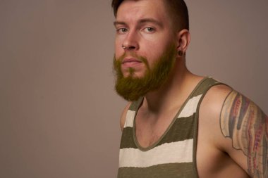 Kollarında dövmeleri olan yakışıklı bir adam. Saç stili duyguları var.