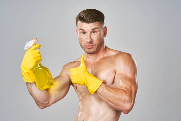 Male naked torso wearing rubber gloves cleaning supplies housework isolated background — Stock Photo, Image