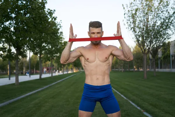 Sportieve man in blauwe broek in het park fitness — Stockfoto
