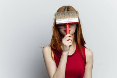 Kırmızı tişörtlü kadın boya onarım servisi için fırça kullanıyor