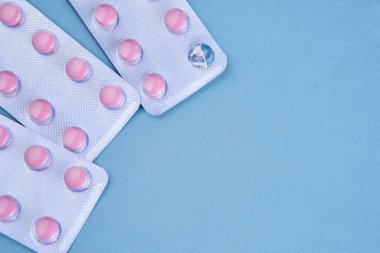 Pembe haplar paketlerde vitaminler ağrı kesici mavi arka plan