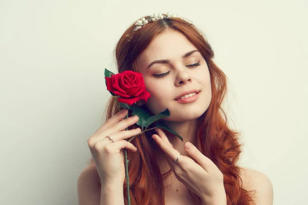 Όμορφη γυναίκα με κόκκινα μαλλιά κόκκινο τριαντάφυλλο λουλούδι κοντά — Φωτογραφία Αρχείου