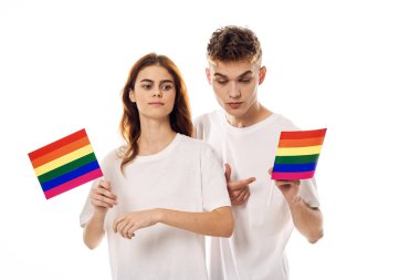 Beyaz tişörtlü genç çift lgbt travesti cinsel azınlıklar bayrağı taşıyor.