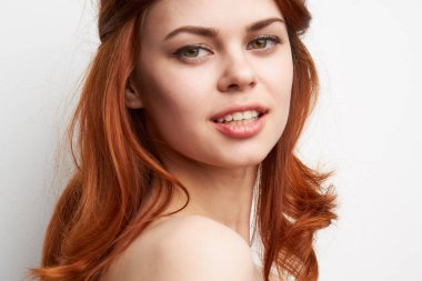 Çıplak omuzlu, neşeli bir kadın. Saç stili, göz alıcı.