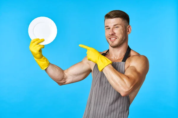 Vaatwasser rubberen handschoenen plaat in handen blauwe achtergrond — Stockfoto