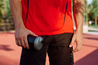 Sportif adam parkta dinleniyor, bankta atıştırıyor.