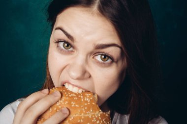 Hamburger yiyen bir kadın.