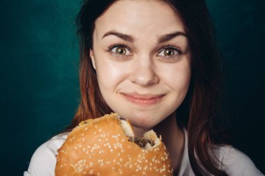 Hamburger yiyen bir kadın.