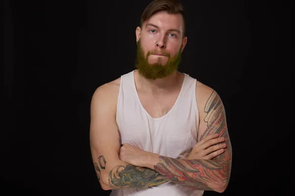 Стильный бородатый мужчина в белой футболке с татуировками на руках — стоковое фото