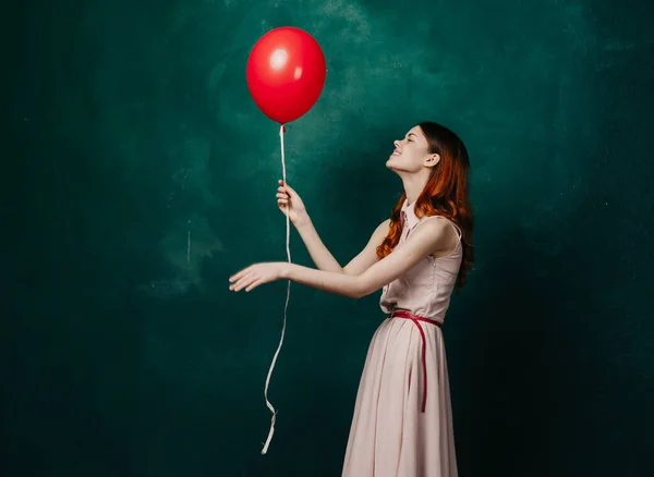 Vrouw met rode ballon viering verjaardag groene achtergrond — Stockfoto