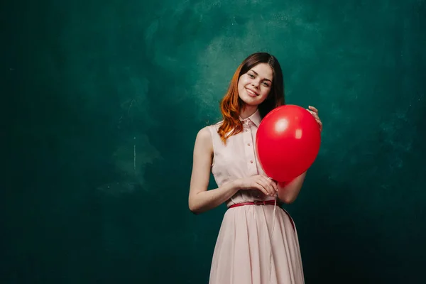 Bonita mujer en vestido rojo globo cumpleaños verde fondo — Foto de Stock