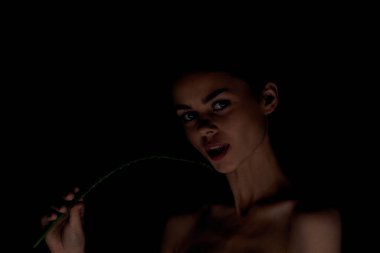 Çıplak omuzlu bir kadın. Açık tenli, aloe organik koyu arkaplan.