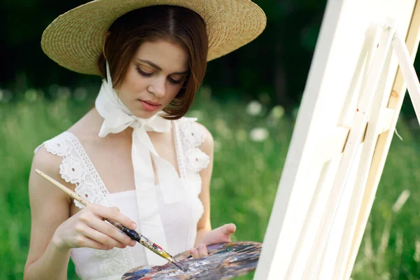 Kobieta artysta rysuje obraz na sztaludze na zewnątrz — Zdjęcie stockowe