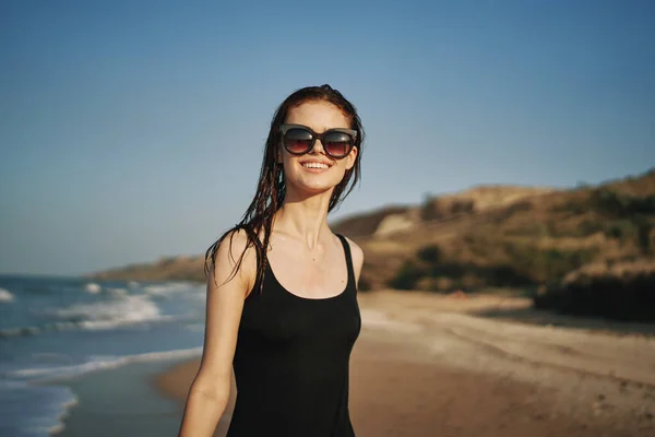 Femme gaie en maillot de bain noir marchant le long de la plage tropiques été — Photo