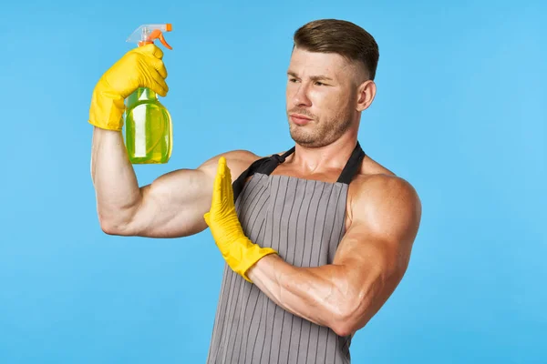 Człowiek z napompowanym ciałem w fartuchu czyszczącym detergenty — Zdjęcie stockowe
