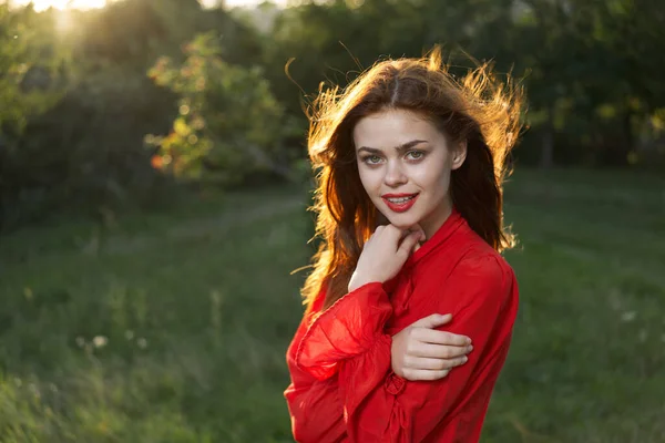 Cheerful woman in a red dress in a field outdoors fresh air — Stock Photo, Image