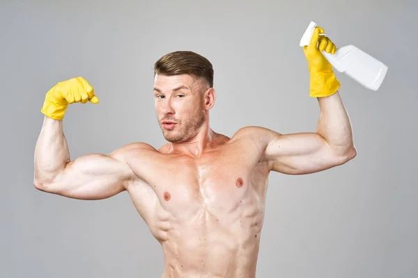 Pompato fino uomo posa con detergente in guanti di gomma — Foto Stock