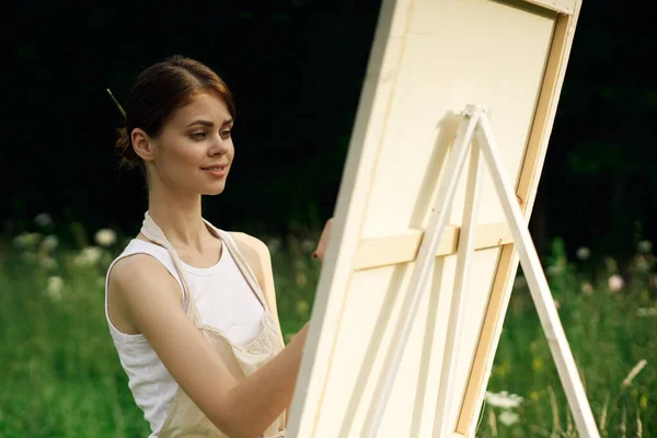 Γυναίκα καλλιτέχνης ζωγραφίζει μια εικόνα κοντά easel εξωτερικό τοπίο δημιουργική — Φωτογραφία Αρχείου