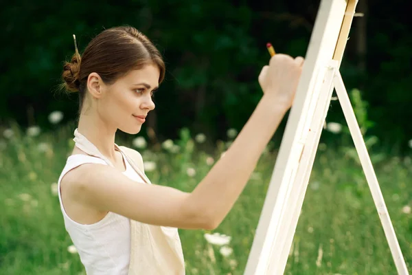 Woman artist paints a picture on nature art hobby — Stock Photo, Image