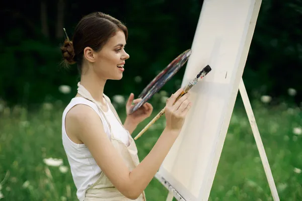 Woman artist with palette of paints drawing easel nature hobby — Stock Photo, Image