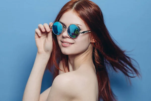 Donna attraente con spalle nude occhiali alla moda sfondo blu — Foto Stock