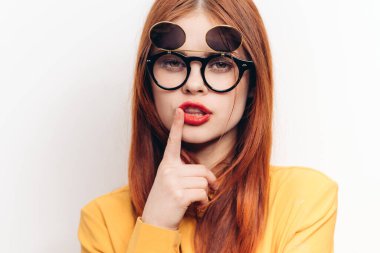 Göz kamaştırıcı kadın güneş gözlükleri, kızıl saçlı açık renk arka plan.