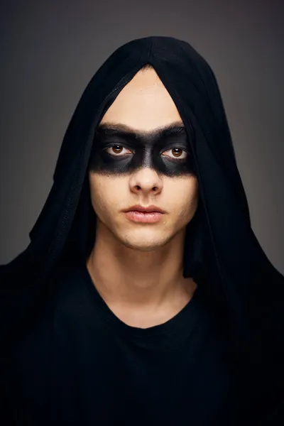 Egy férfi egy fekete maszk Halloween jelmez szellem sötét háttér — Stock Fotó