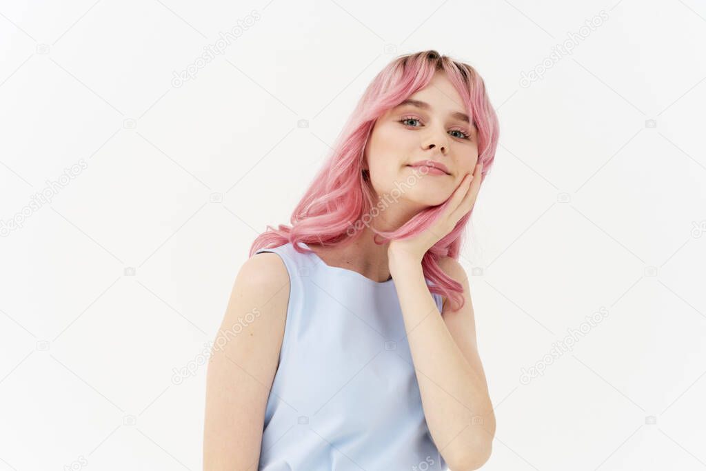woman in blue dress pink hair posing light background