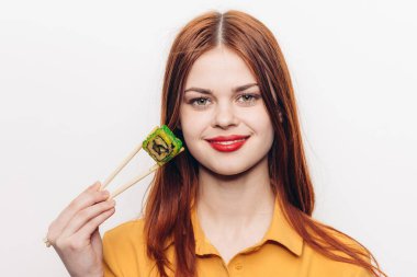 Suşi çubukları yiyen güzel bir kadın.