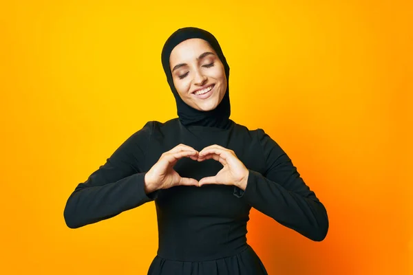 穿着黑色头巾的阿拉伯女人摆出时尚手势工作室的生活方式 — 图库照片