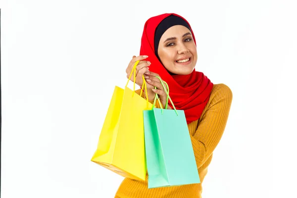 Glad muslimsk kvinna shopping semester gåvor ljus bakgrund — Stockfoto