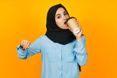 Elinde saat olan Arap kadın. Teknoloji. Duygular sarı arka plan.