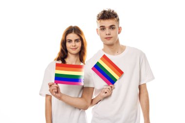 Beyaz tişörtlü genç çift lgbt travesti cinsel azınlıklar bayrağı taşıyor.
