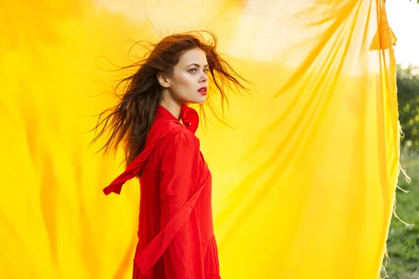 Bella donna in abito rosso tessuto giallo su sfondo natura — Foto Stock