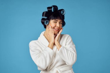 Kafasında bigudilerle ev işi yapan bir ev hanımı.