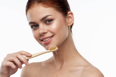 Çıplak omuzlu, neşeli bir kadın diş fırçası, diş fırçası, ağız bakımı.